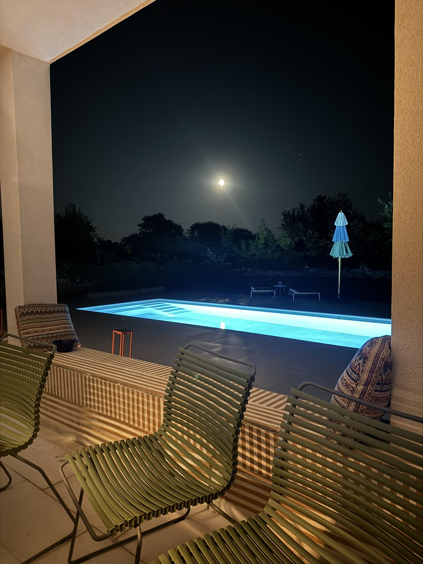 The lit pool under a full moon
